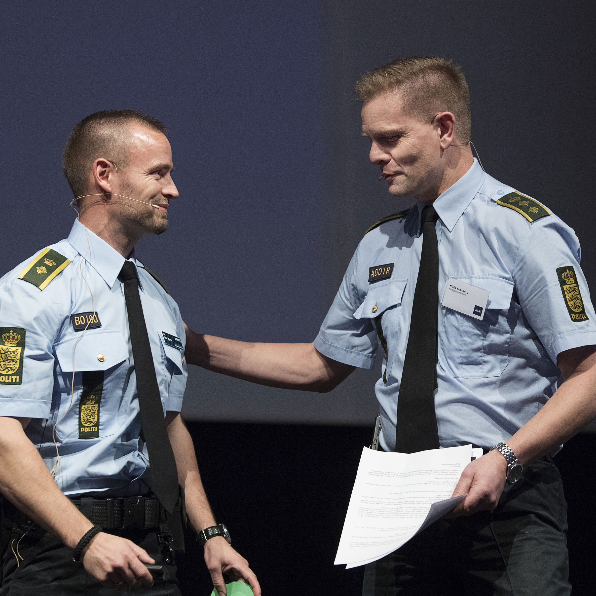 To betjente, der taler sammen til et borgermøde om forebyggelse af indbrud