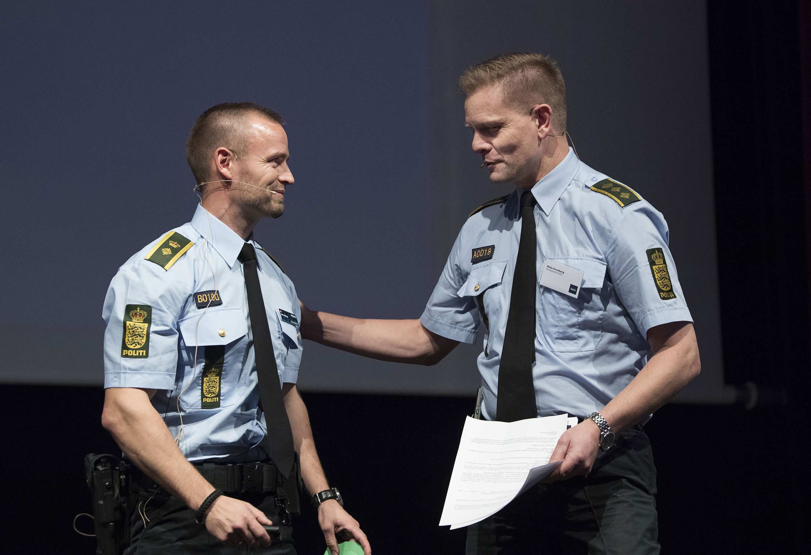 To betjente, der taler sammen til et borgermøde om forebyggelse af indbrud