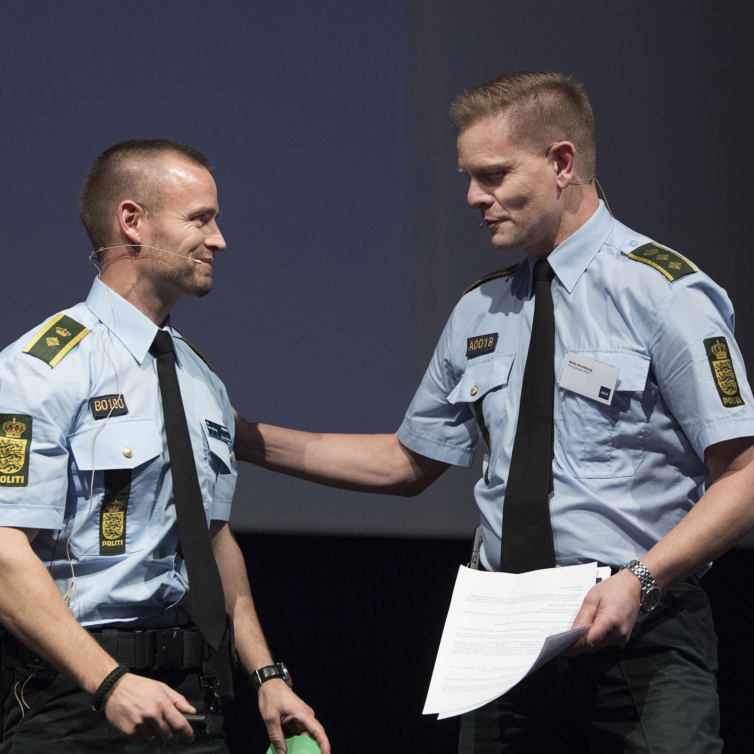 To betjente, der taler sammen til et borgermøde om forebyggelse af indbrud