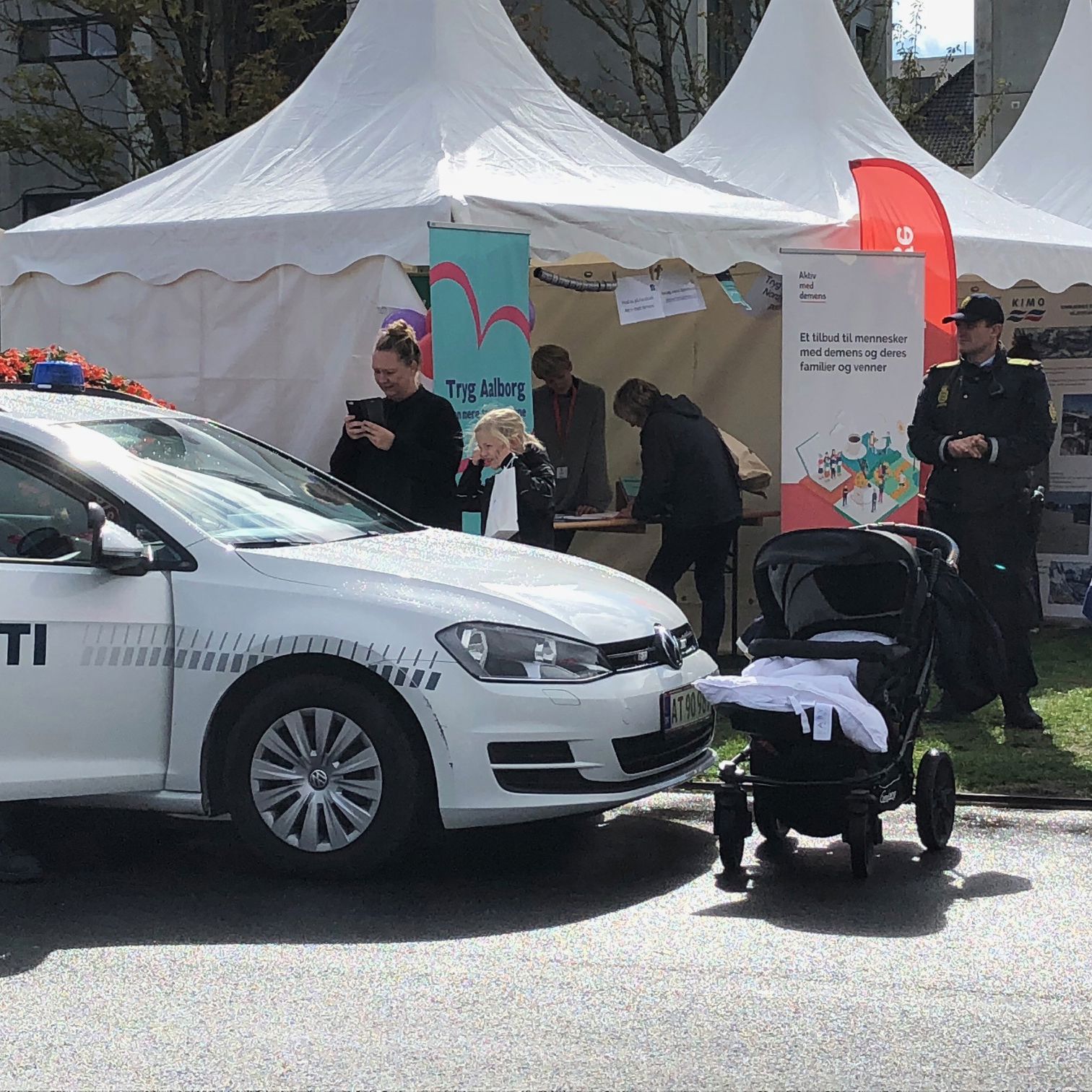 Politibil, der holder foran nogle hvide telte