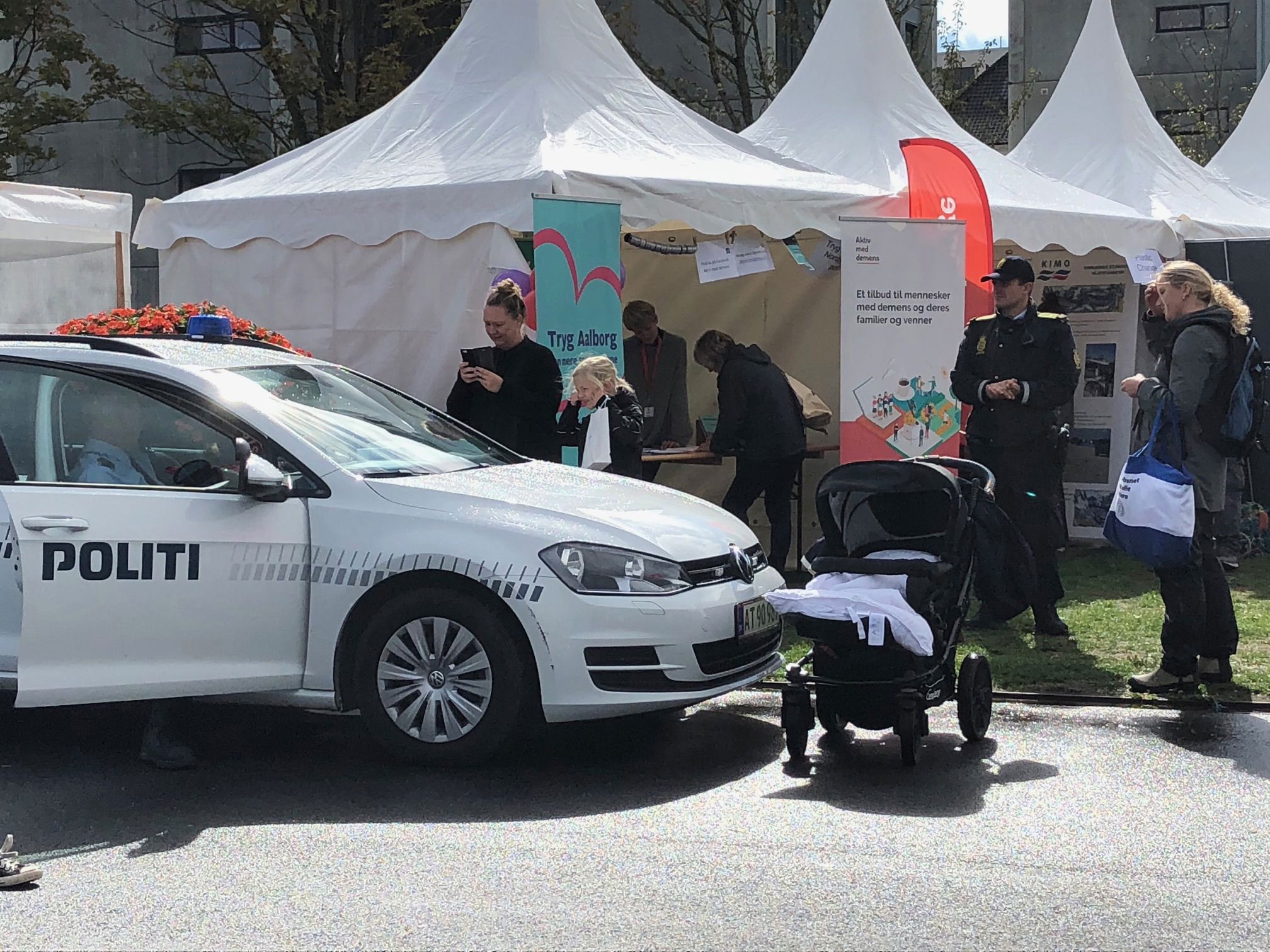 Politibil, der holder foran nogle hvide telte