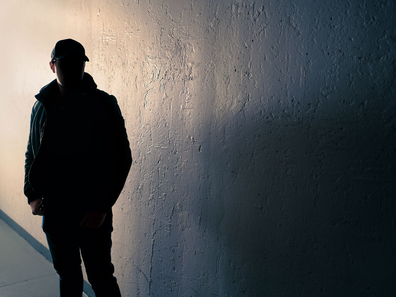 Person med ryggen mod muren
